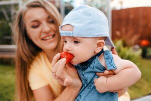 Mom and baby eating strawberry