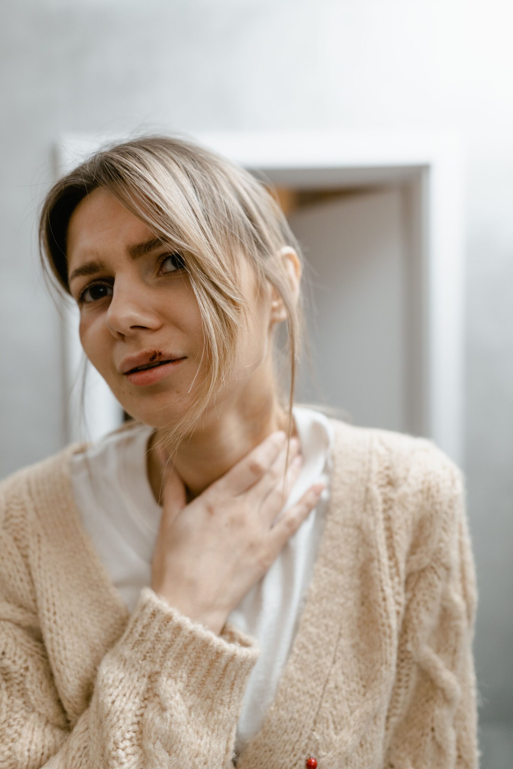 woman looking in mirror at neck or thyroid